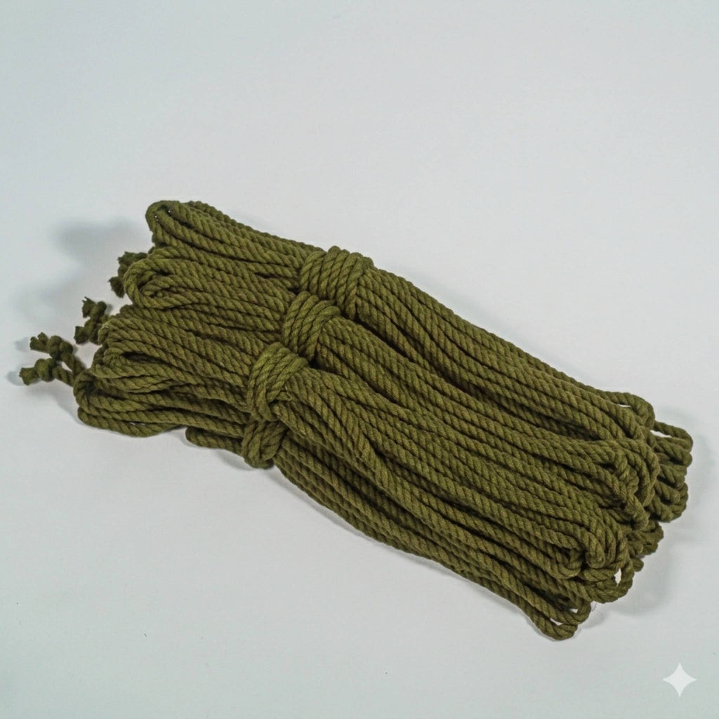 Bundle of green cotton rope on a light gray background